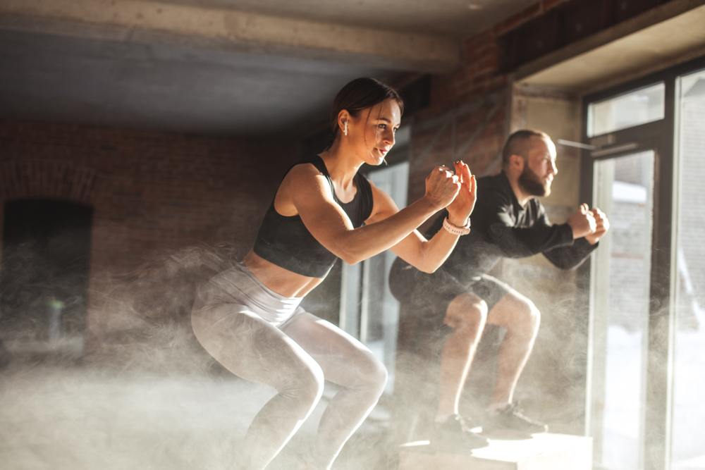 Moški in ženska izvajata CrossFit vaje na kocki, ki vam bodo dodobra pospešile srčni utrip.