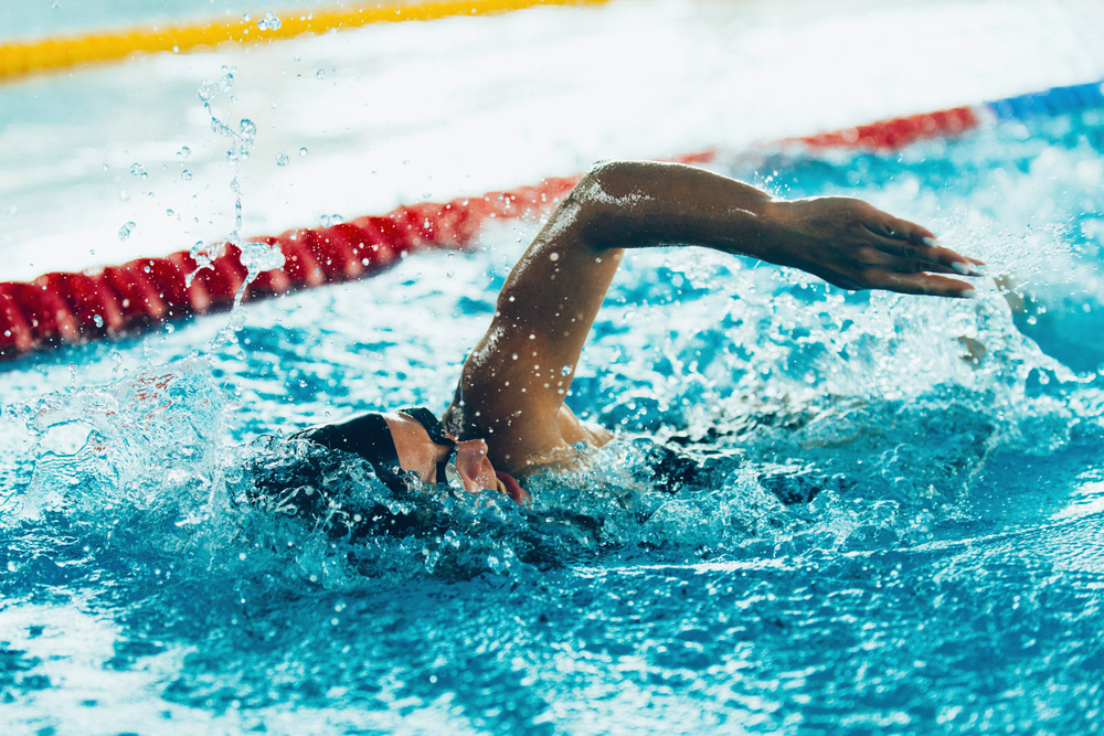 Plavalec v olimpijskem bazenu izvaja prosto tehniko plavanja (kravl).