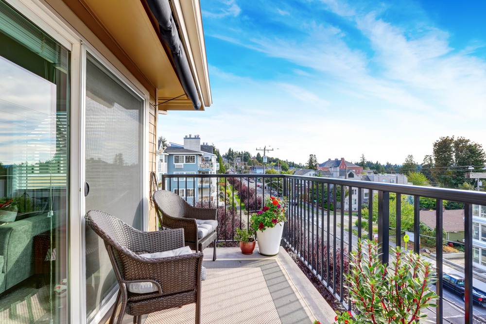 Pogled na lepo opremljen balkon in kovinsko ograjo, ki ga lepo poveže z okolico. 