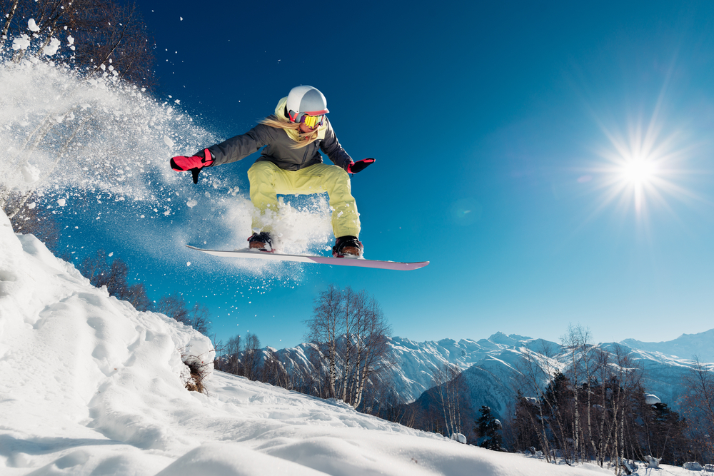 Ženska skače s snowboardom.