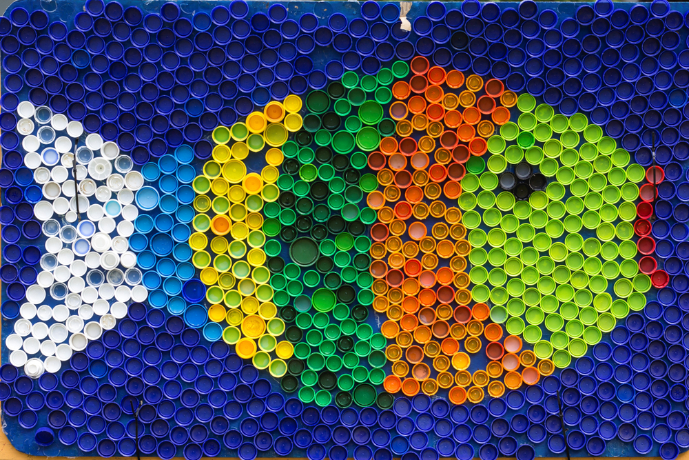 Mozaik v obliki ribe, ki je izdelan iz pisanih plastičnih zamaškov.