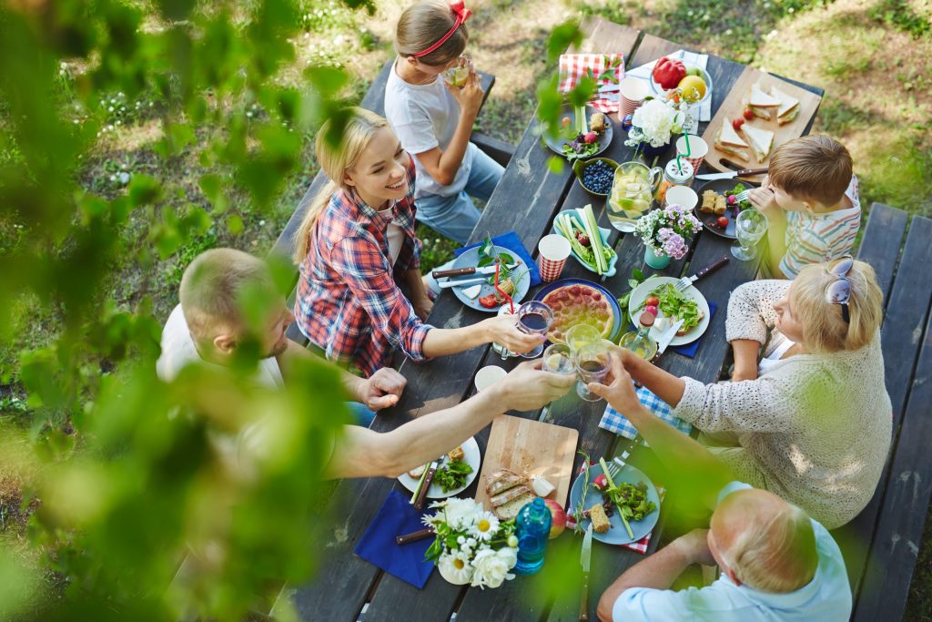 Družina uživa za obloženo mizo ob dobrih piknik prigrizkih.